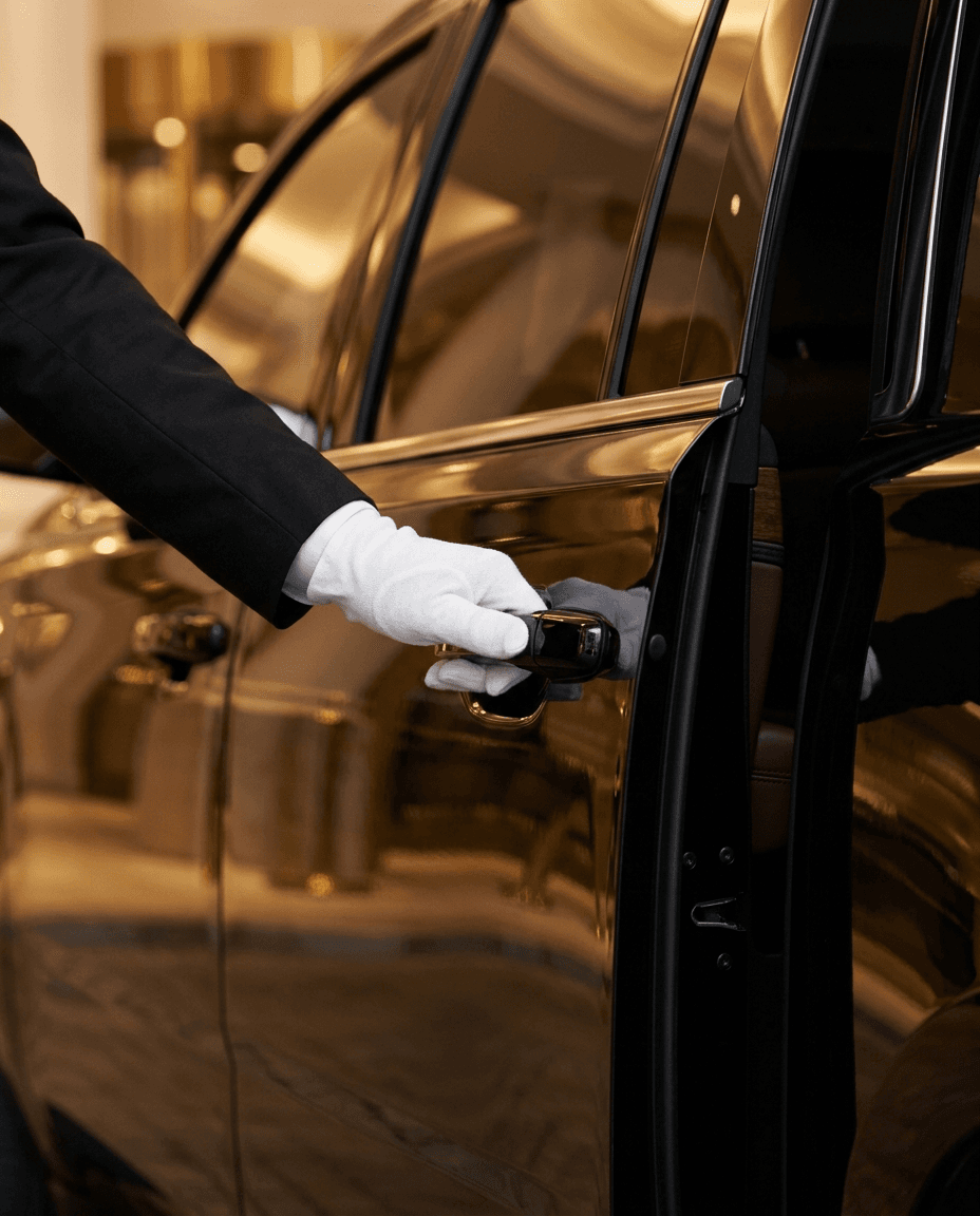 Professional chauffeur opening door of black luxury SUV Bay Area